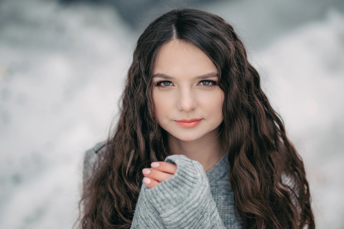 Jeune fille aux cheveux long et soyeux sous la neige cet hiver