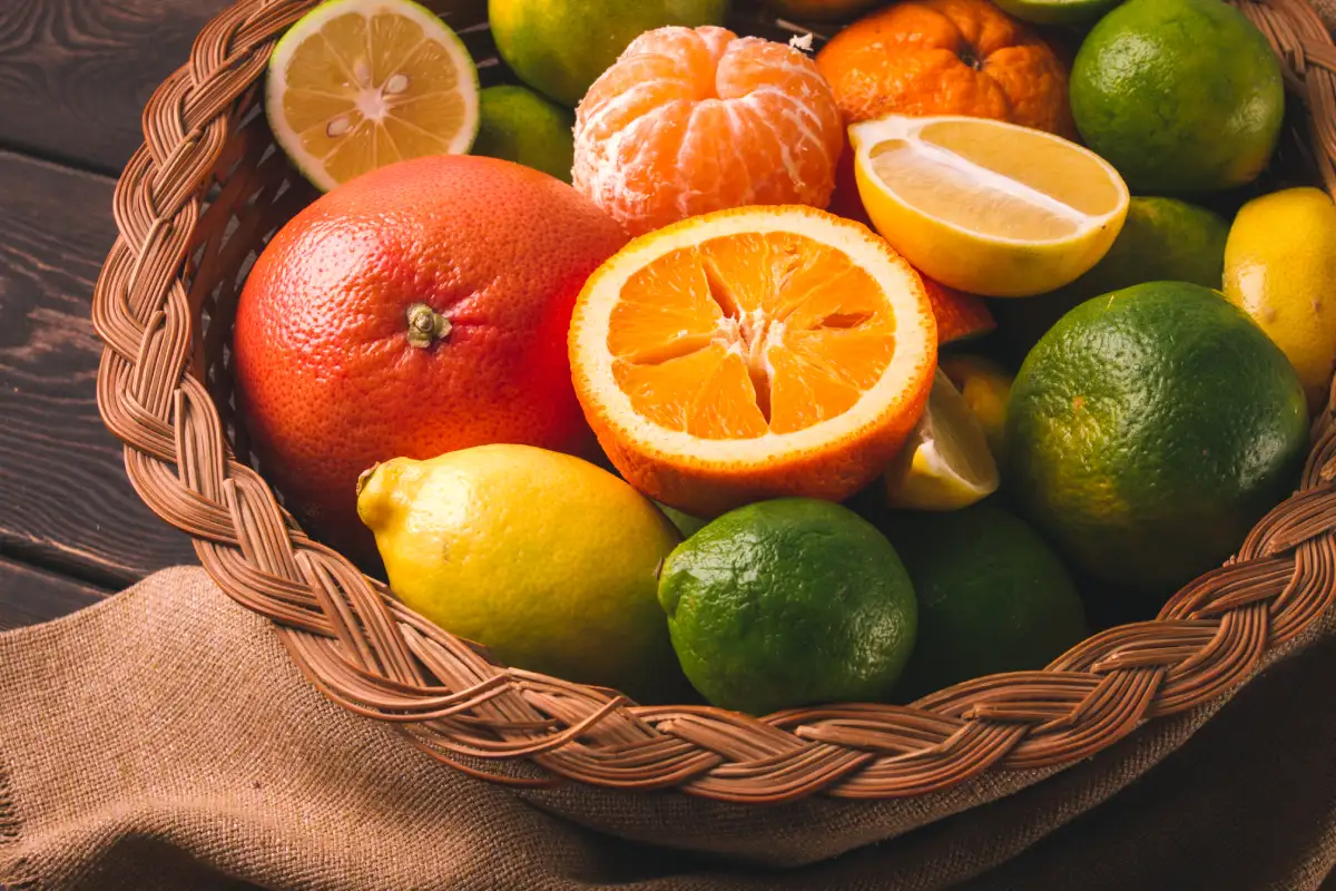 Panier de fruits et légumes frais avec des flacons de vitamines B, C et D sur une table en bois, symbolisant une alimentation saine