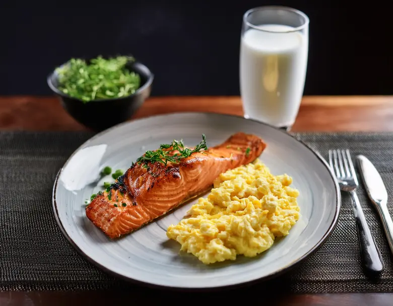 Repas sain avec saumon grillé, œufs brouillés et lait enrichi, source de vitamine D