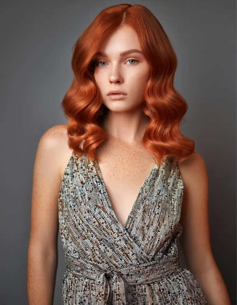 Femme rousse avec des taches de rousseur et un bob ondulé, portant une robe d'été