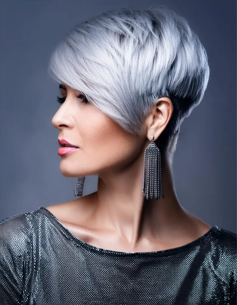 Femme avec une coupe pixie texturée sur cheveux argentés, fond élégant