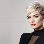 Femme moderne avec une coupe Pixie blonde, chic et élégante.