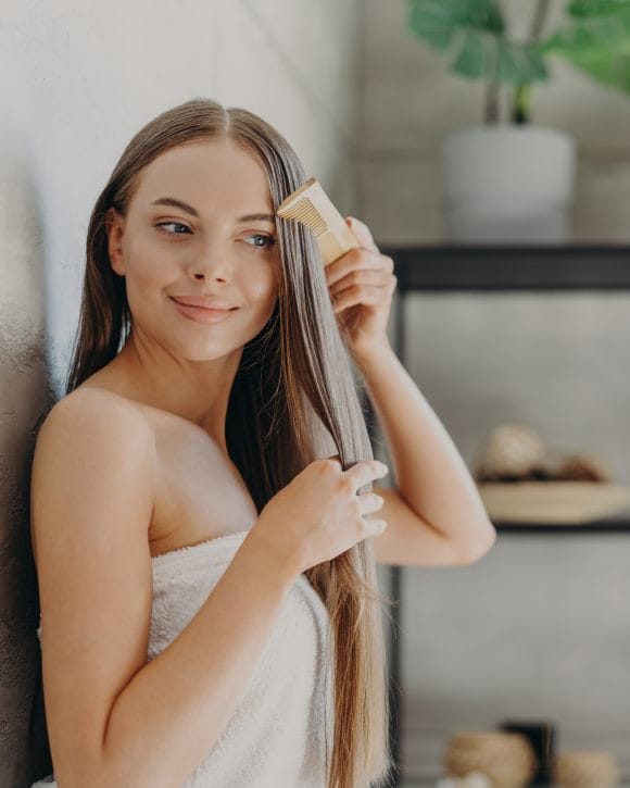 Fille au long cheveux applique un masque brillance fait maison