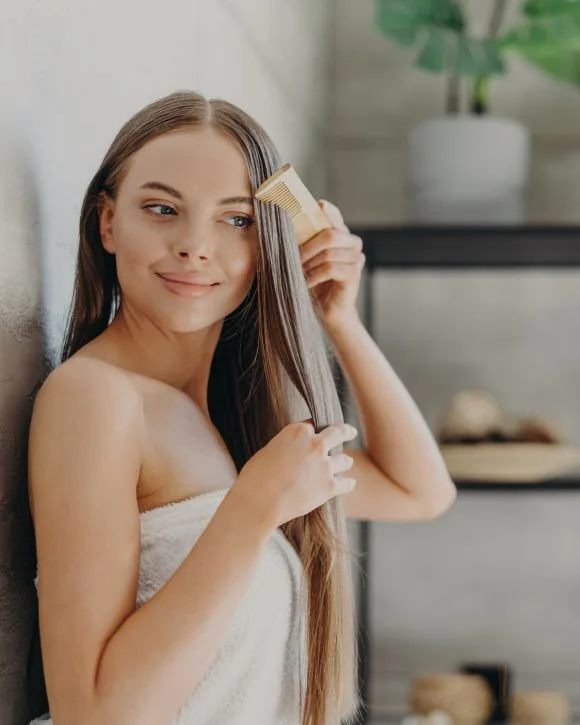 Fille au long cheveux applique un masque brillance fait maison