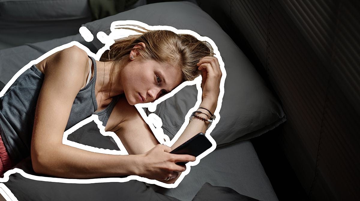 Jeune femme anxieuse regardant son téléphone, illustration de l'anxiété relationnelle dans le couple moderne