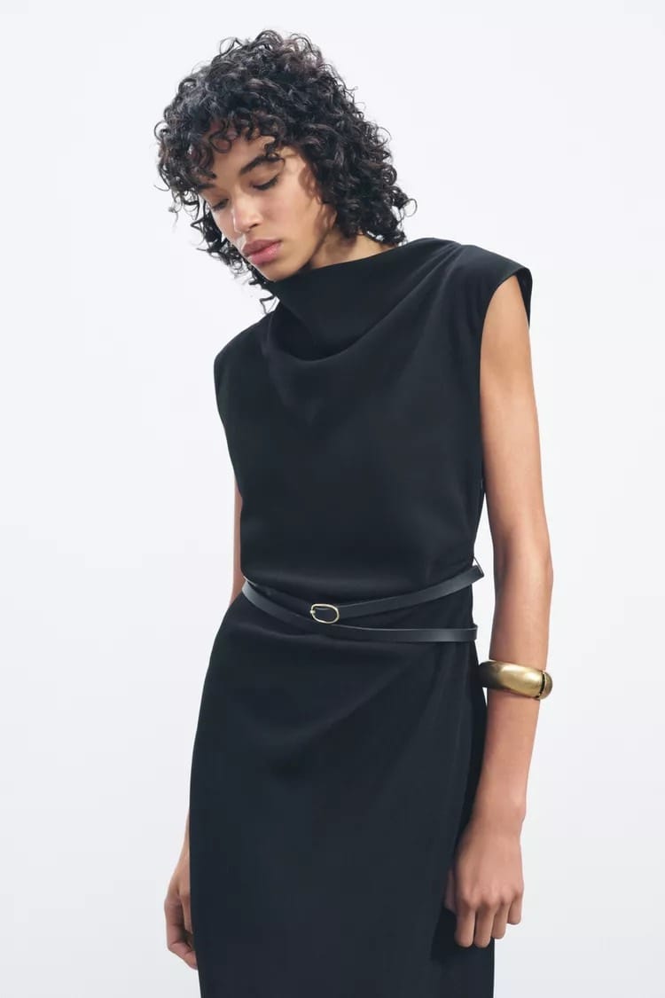Femme vêtue d'une robe midi noire Zara avec ceinture noire, automne 2024