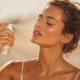Femme rafraîchissant sa peau avec une brume hydratante pendant la canicule