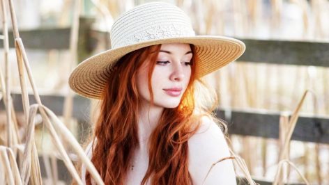 Femme élégante portant un chapeau de paille sous le soleil