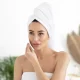 Femme dans salle de bain qui se démaquille les yeux avec un coton démaquillant