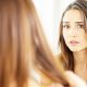 Femme inquiète devant le miroir, examinant ses cheveux