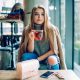 Femme assise confortablement avec une tasse de thé, des livres et des suppléments de vitamines, illustrant le bien-être mental