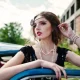 Photo d'une fille en tenue Gatsby accoudée sur une voiture des années 20