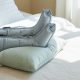 Jambes surélevées équipées de bottes de pressothérapie gonflables sur un lit clair, ambiance bien-etre