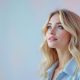Femme blonde portant une tenue pastel, avec un look élégant et harmonieux, idéal pour sublimer les cheveux blonds en hiver.