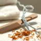Ciseaux de coiffeur et peigne à dents larges posés sur du marbre, avec des mèches de cheveux bouclés coupées à sec