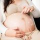 Femme enceinte appliquant de la crème sur son ventre pour prévenir les vergetures