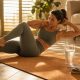 Tapis de sport au sol dans un salon aux volets mi-clos, avec un verre d'eau fraîche et un petit ventilateur pendant une journée de canicule