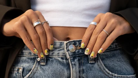Faux ongles à coller de qualité sur les mains d'une femme