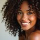 Gros plan d’une femme aux boucles bien définies et brillantes, avec des cheveux volumineux et hydratés, capturant la beauté naturelle des cheveux bouclés.