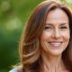 Femme de 40 ans aux cheveux brillants et soyeux souriant avec confiance, incarnant la beauté et la vitalité