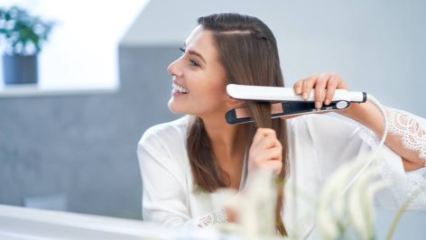 Jeune femme coiffée avec un lisseur GHD
