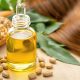 Flacon d’huile de ricin avec gouttes d’huile et cheveux brillants
