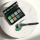 Palette de maquillage vert et noir sur marbre clair, ombre d'un chapeau de sorcière en lumière naturelle