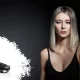 Fille blonde avec robe noire et aux cheveux lisses avec un lisseur sans fil GHD