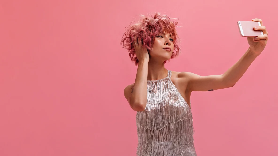 Femme aux cheveux courts qui test une coloration avec une application sur son smartphone
