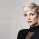 Femme moderne avec une coupe Pixie blonde, chic et élégante.