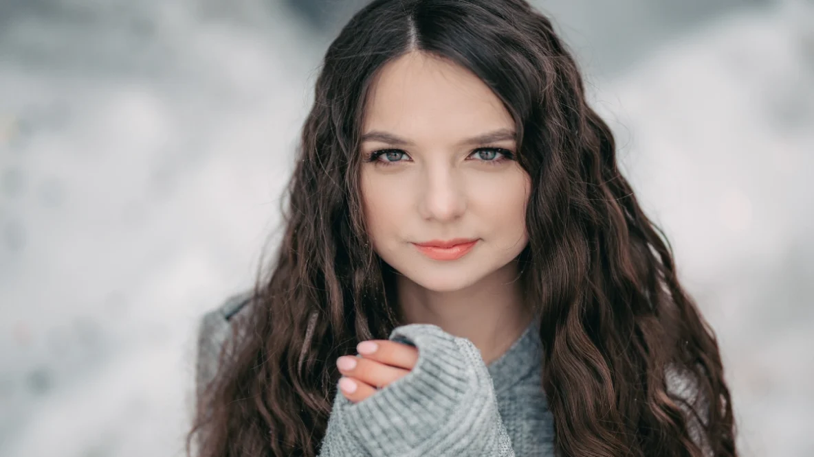 Jeune fille aux cheveux long et soyeux sous la neige cet hiver