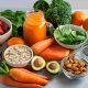 Assortiment de sources naturelles de vitamines : carottes, épinards, patates douces, agrumes, saumon, noix, graines et plats équilibrés pour une alimentation saine