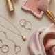 Beauté et style : rouge à lèvres, foulard en soie et bijoux sur fond neutre