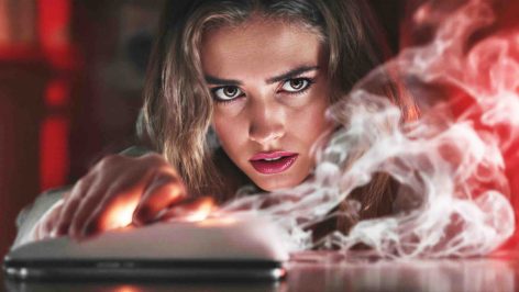 une jeune femme inquiète devant un lisseur fumant ou oublié sur une table.